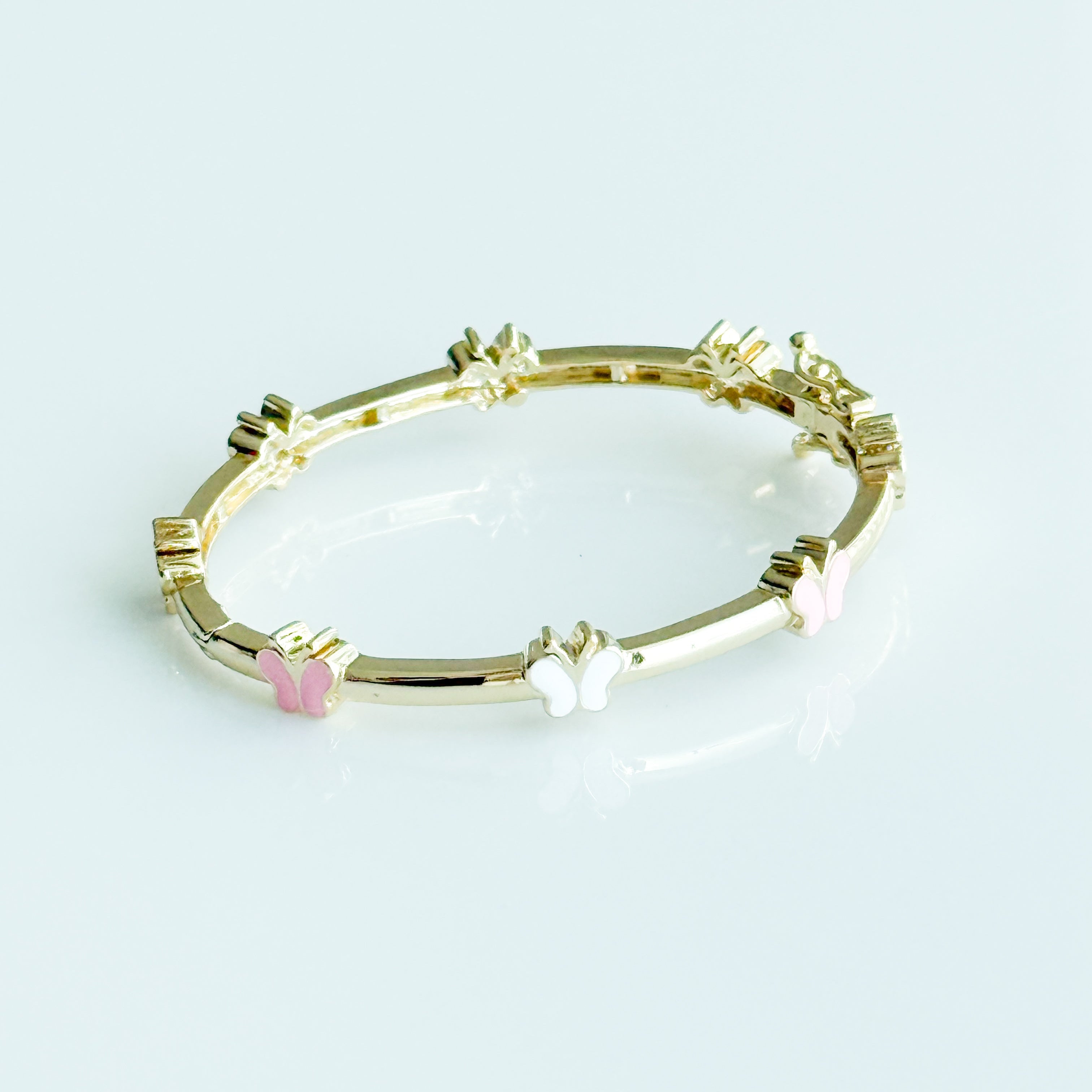 Gold bracelet with colorful beads on a light blue background