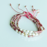 Beaded bracelet with pink and white beads on a light gray background