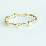 Gold bracelet with floral designs on a white background