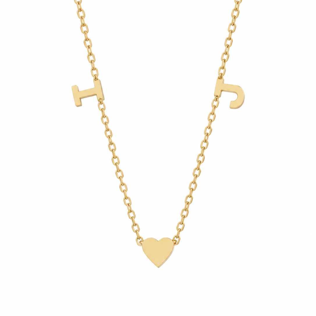 14K yellow gold necklace with I and J initials and a polished center heart on a delicate diamond-cut chain.