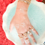 Hand with gold jewelry on a red and white background