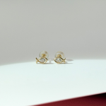 Gold fish-shaped earrings on a light gray background