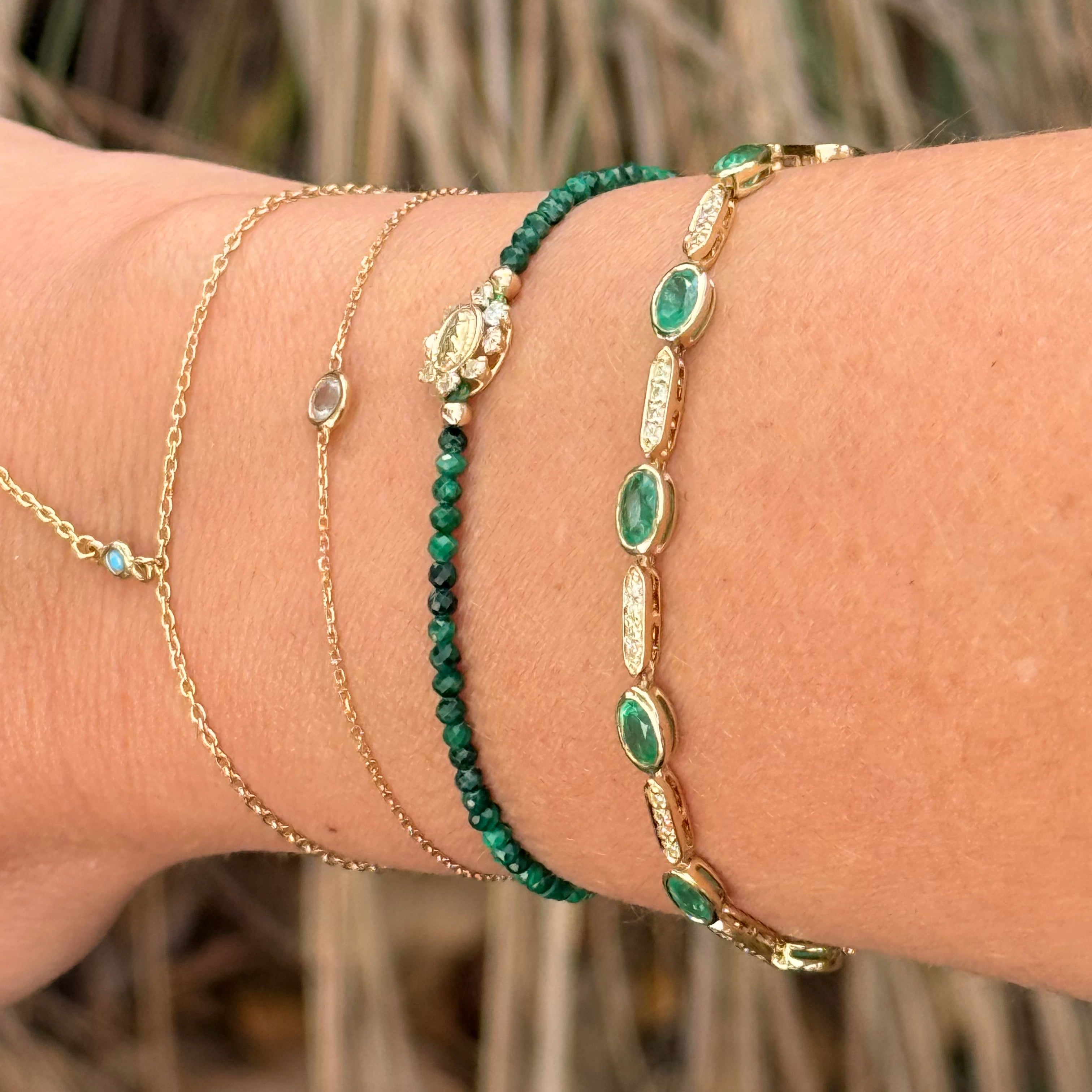 Close-up of a wrist wearing multiple bracelets with a natural background