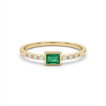     Delicate 14K yellow gold emerald cut green CZ ring with diamond accents held between fingers