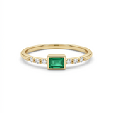     Delicate 14K yellow gold emerald cut green CZ ring with diamond accents held between fingers