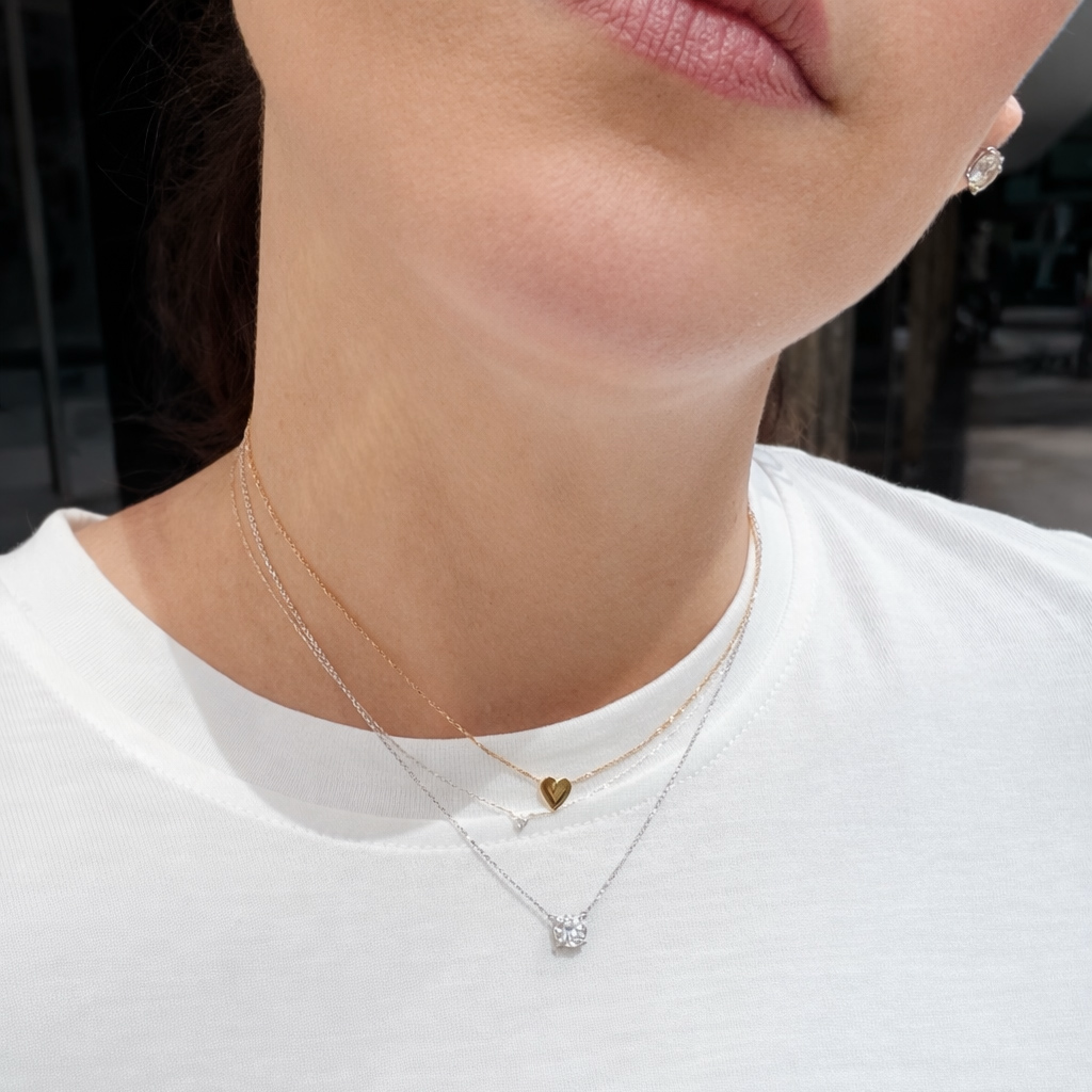 1 ct certified lab-grown diamond necklace in 14K white gold layered with delicate gold necklaces on model