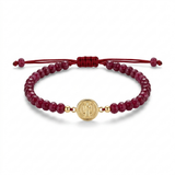 14K solid yellow gold Saint Benedict bracelet front view with Indian ruby stones, red satin adjustable macramé cord, and front-facing Saint Benedict medal
