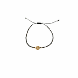 Terahertz black stone bracelet with adjustable macramé cord and 14K solid gold double face San Benito medal on white background