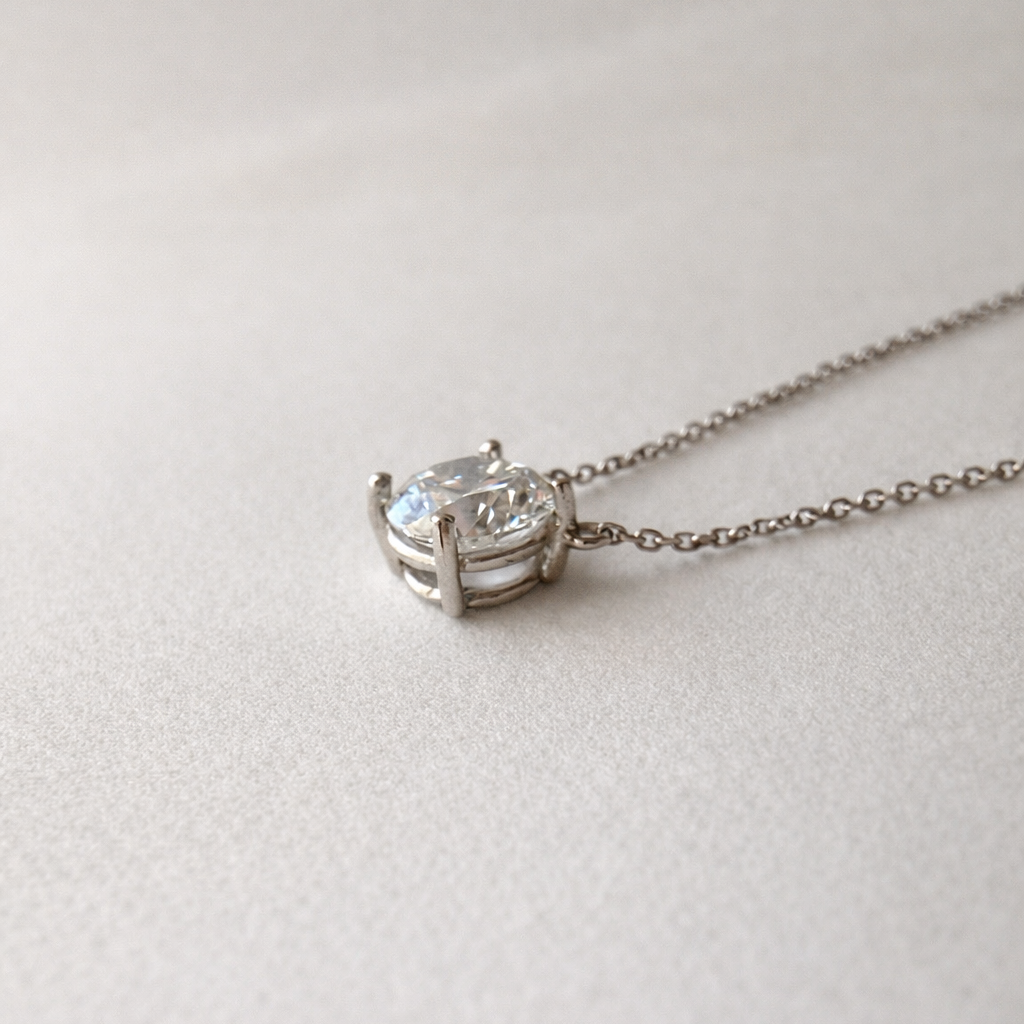 close-up side view of 1 ct certified lab-grown diamond necklace in 14K white gold on soft neutral fabric