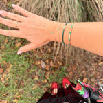 Hand with multiple bracelets on a natural background