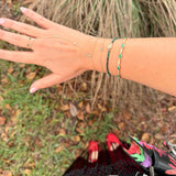 Hand with multiple bracelets on a natural background