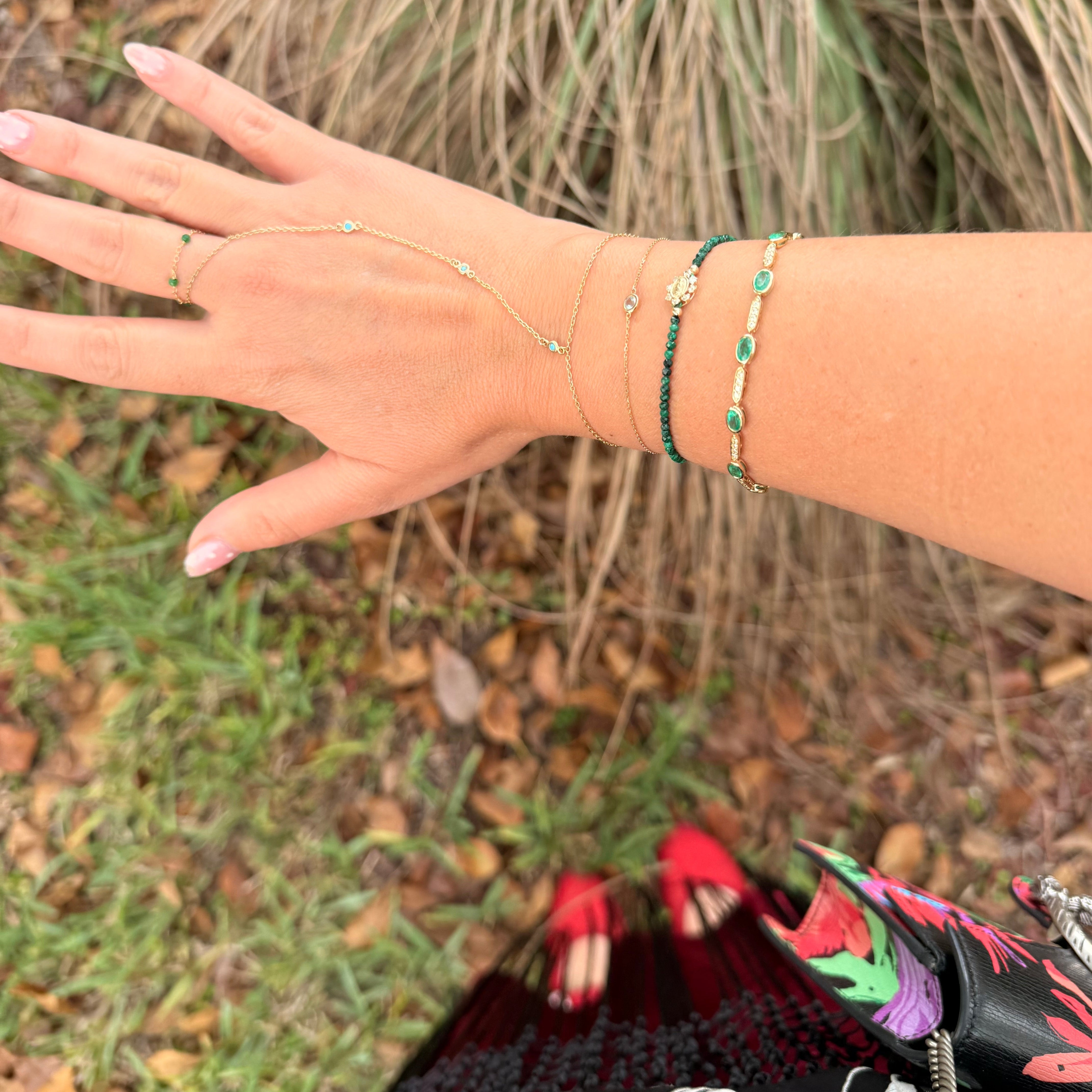 Hand with multiple bracelets on a natural background