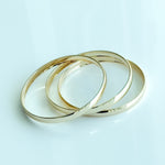 Three gold rings stacked on a light blue background