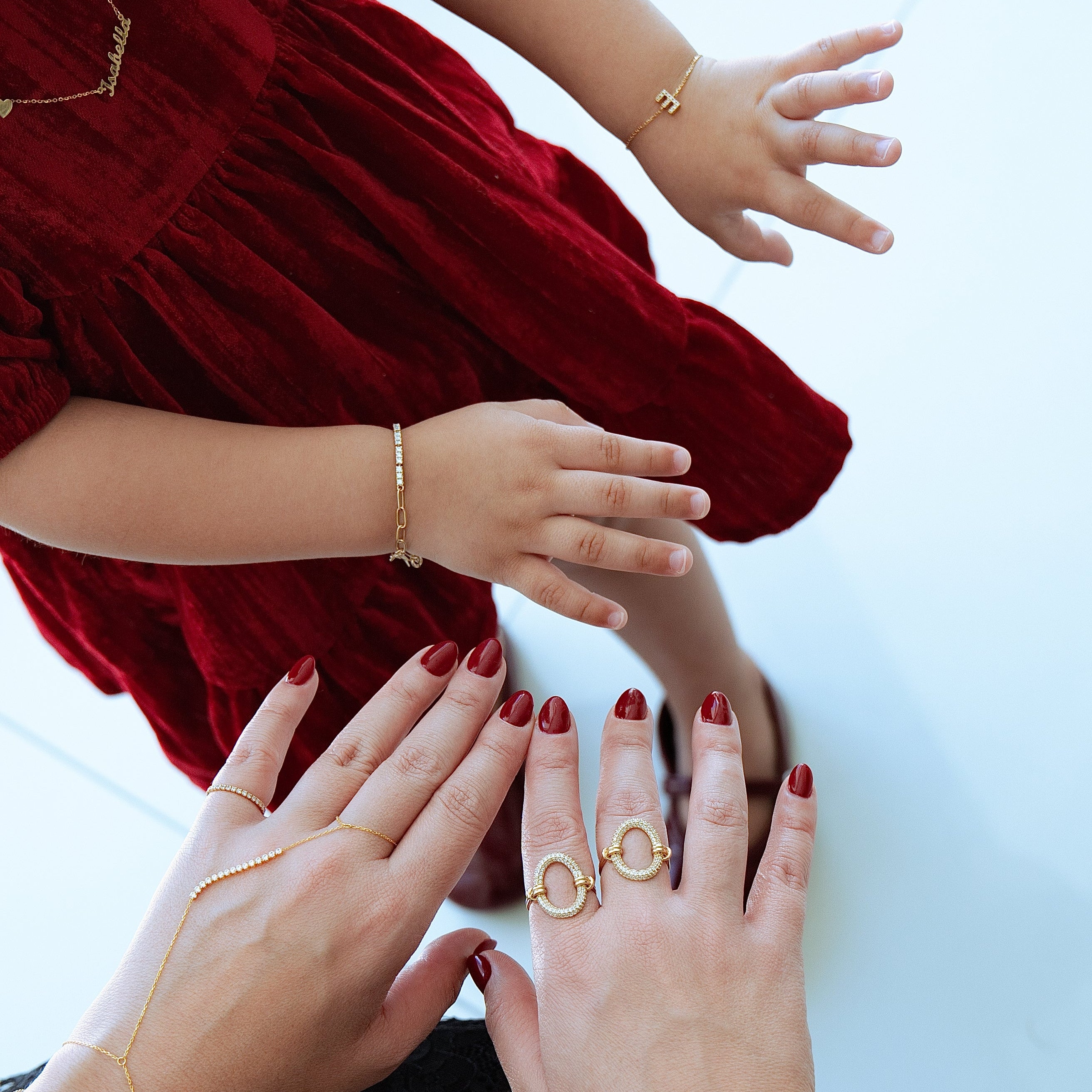 Close-up of hands with gold rings and bracelets on a white background