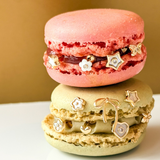 Two macarons stacked on top of each other with decorative jewelry on a beige background