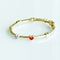 Gold bracelet with heart-shaped charms on a white background