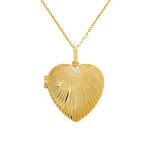 Gold-plated sterling silver heart locket necklace with bezel-set round diamond detail, lifestyle close-up on layered necklaces