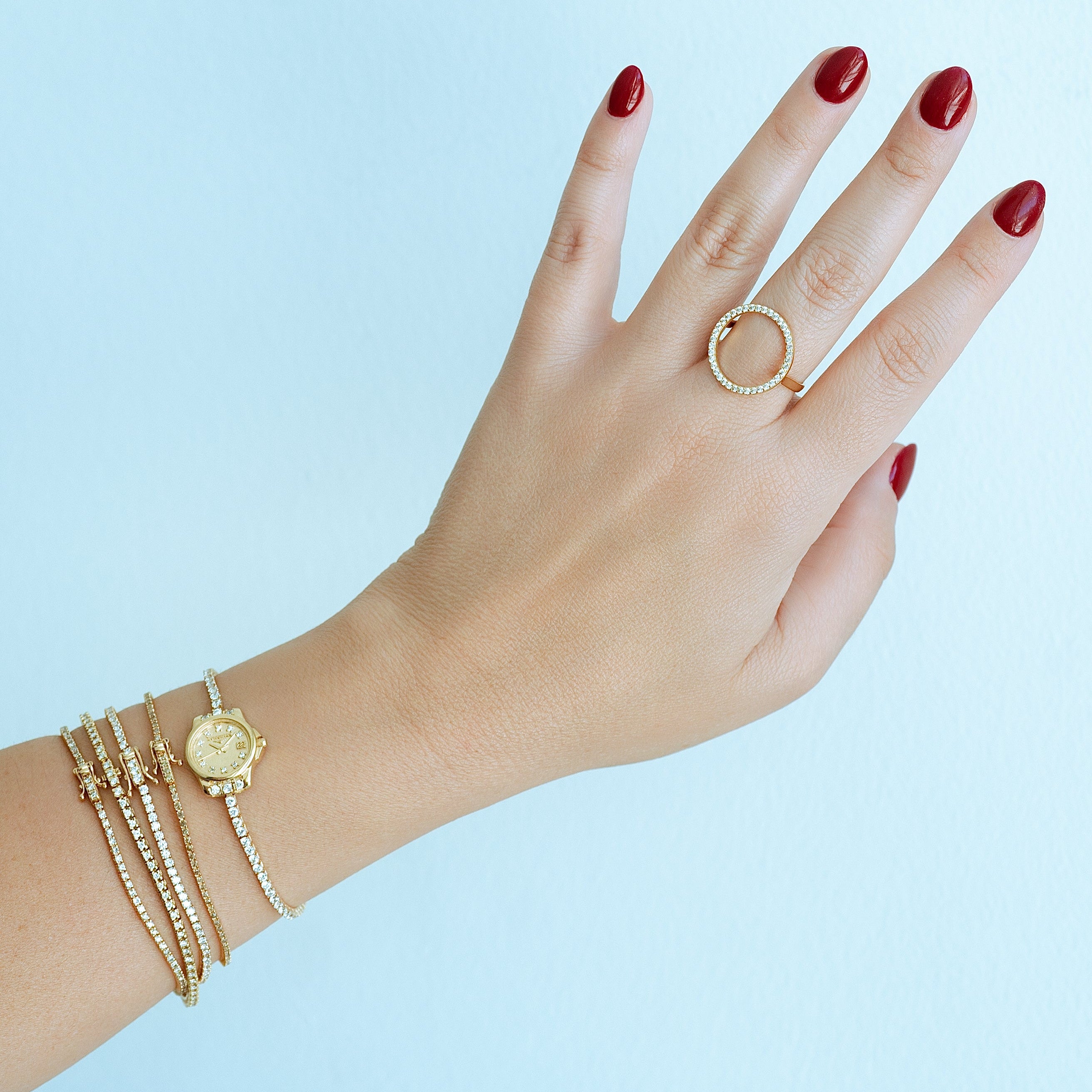 champagne diamond bracelet on wrist stacked with gold jewelry