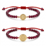 Two red beaded bracelets with gold medallions on a white background