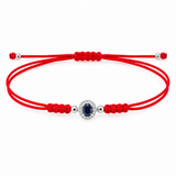 14K solid white gold red silk cord bracelet featuring a natural oval blue sapphire surrounded by pavé diamonds, four polished white gold beads and an adjustable sliding knot closure.