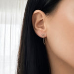 Woman wearing a 14K solid yellow gold open heart cubic zirconia chain earring with a delicate double chain detail for a layered look.
