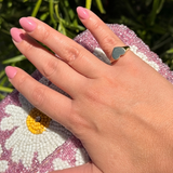 Lifestyle close-up of a hand wearing a polished 14K solid yellow gold heart signet ring with a 9.10 mm heart top.