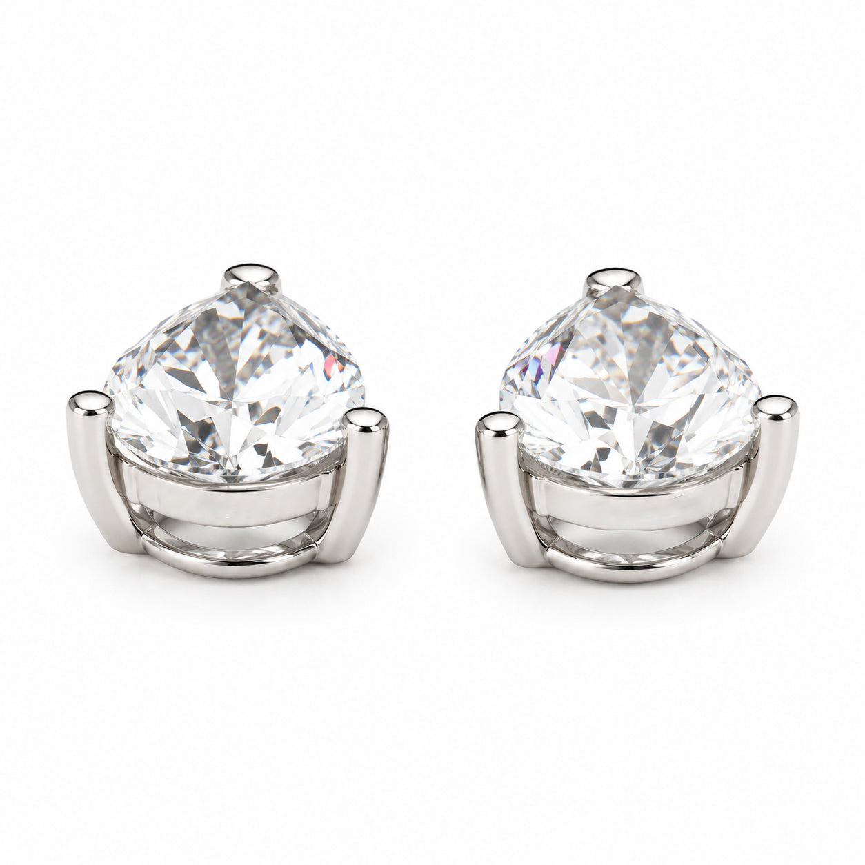 Side view of a pair of certified pear-cut lab-grown diamond earring charms in solid 14K white gold, showing the three-prong settings and polished metal bases.