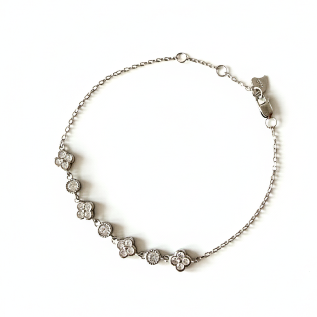 Silver clover bracelet with diamond accents on delicate chain, photographed on a clean white background