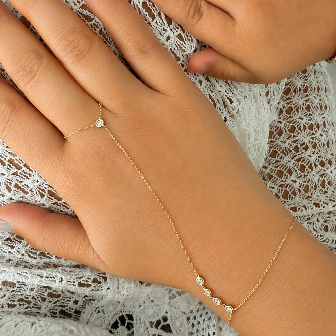 14K solid yellow gold hand chain bracelet with five bezel-set natural diamonds worn on the wrist.