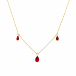 14K yellow gold necklace with three pear-shaped genuine ruby charms on a delicate chain, photographed on a clean white background.