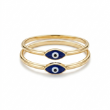 Two delicate blue evil eye rings in 14K yellow gold photographed on white surface