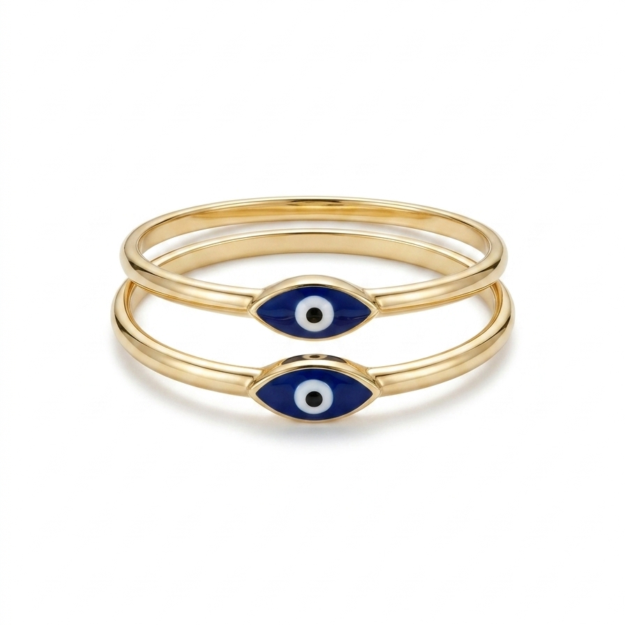 Two delicate blue evil eye rings in 14K yellow gold photographed on white surface