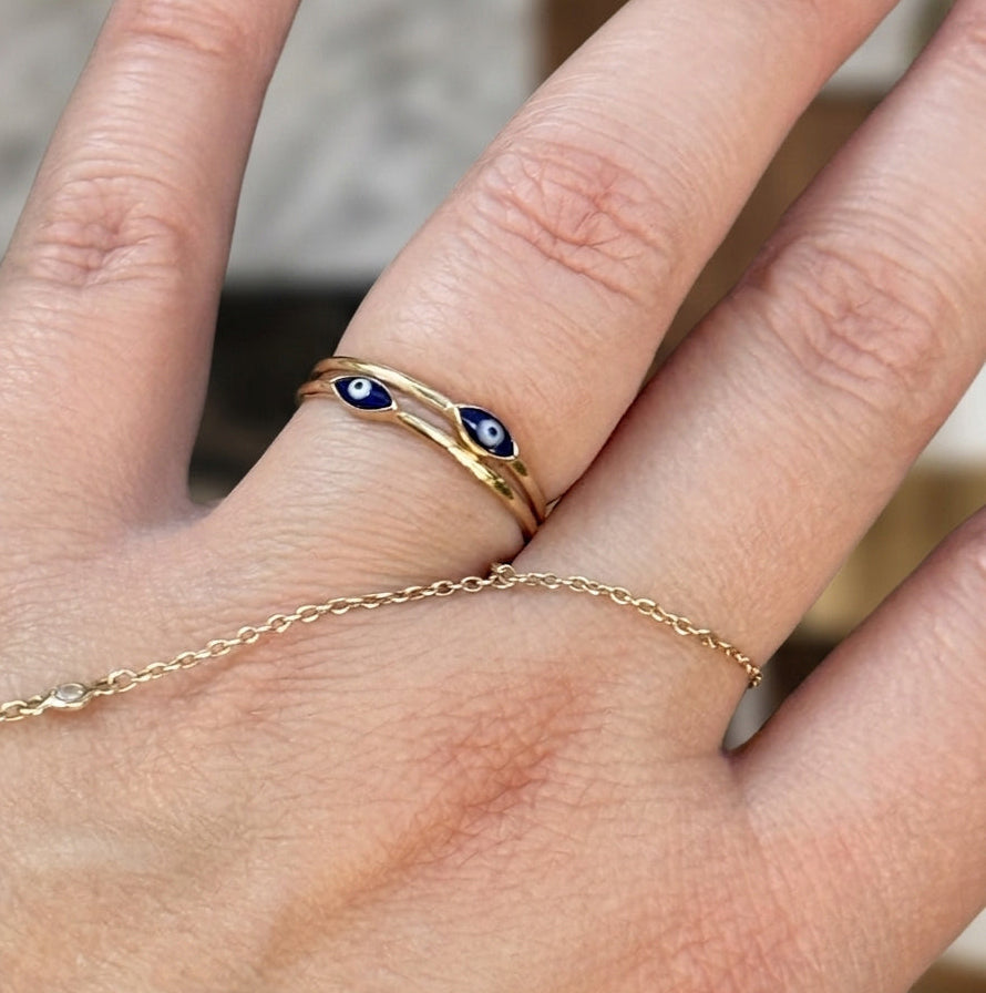  Stackable 14K gold evil eye rings styled on hand outdoors in natural light