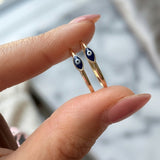 Minimalist 14K solid yellow gold blue evil eye ring held between fingers
