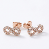 14K solid rose gold infinity stud earrings with natural diamond accents and push backs on white background.