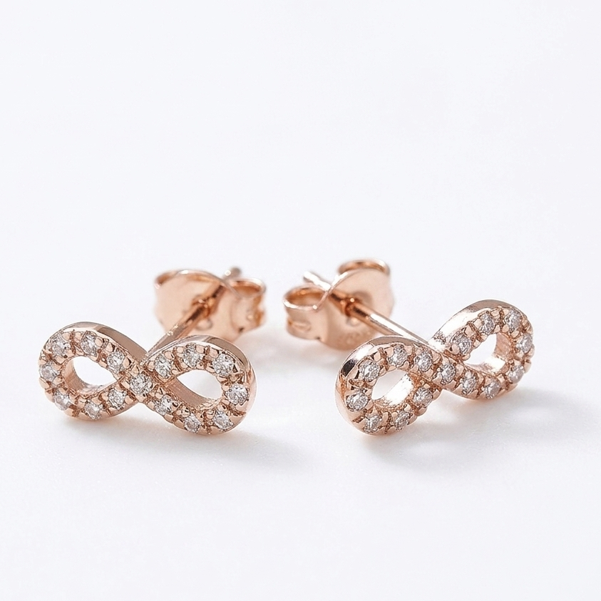 14K solid rose gold infinity stud earrings with natural diamond accents and push backs on white background.