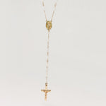 Gold necklace with a cross pendant on a light gray background