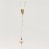 Gold necklace with a cross pendant on a light gray background