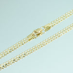 Gold chain necklace on a light blue background