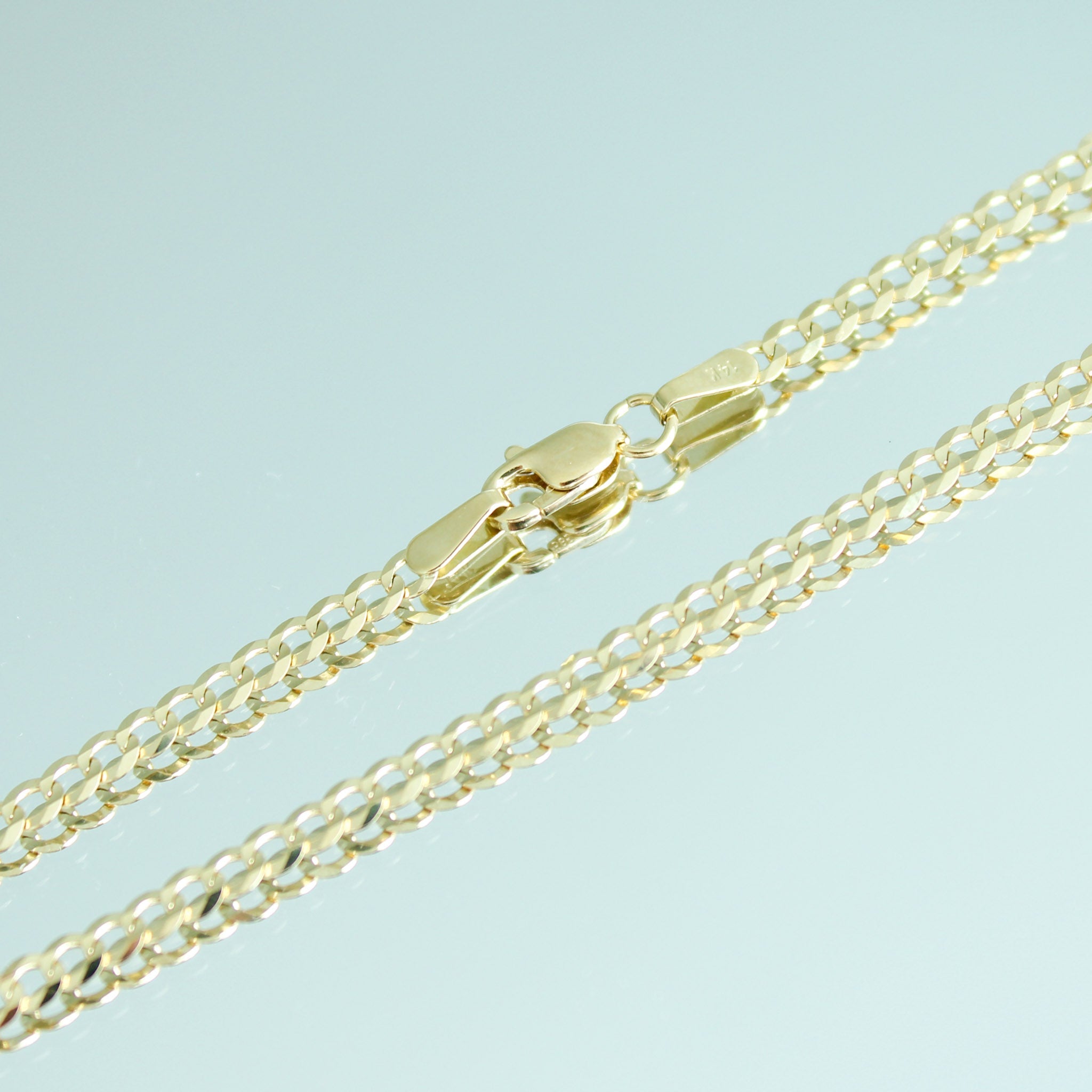 Gold chain necklace on a light blue background