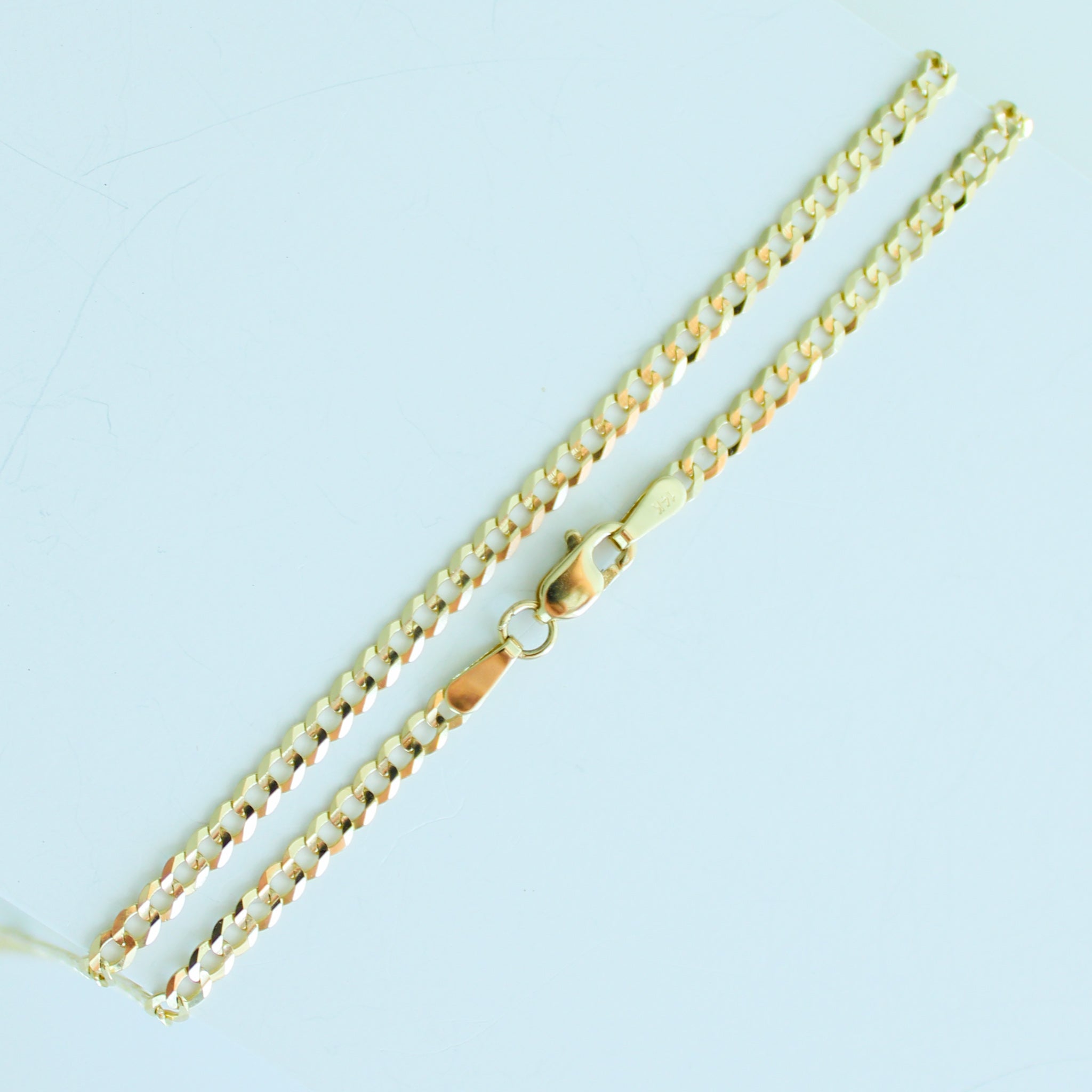 Gold chain necklace on a light blue background