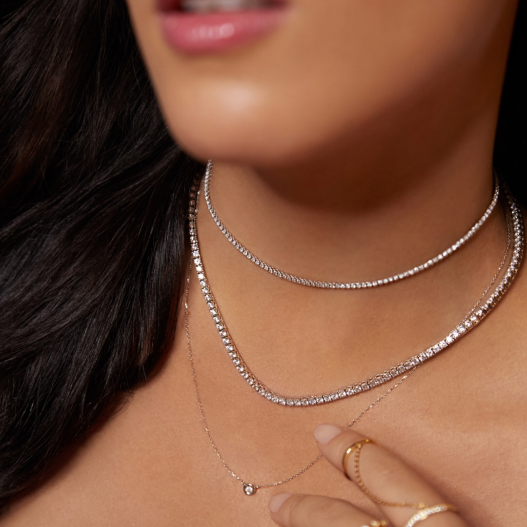 Close-up of a woman wearing two necklaces with a blurred background