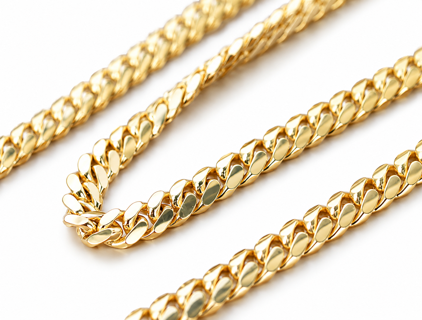 Close-up of a 14K solid yellow gold 6 mm Cuban link chain with polished interlocking links on a white background.