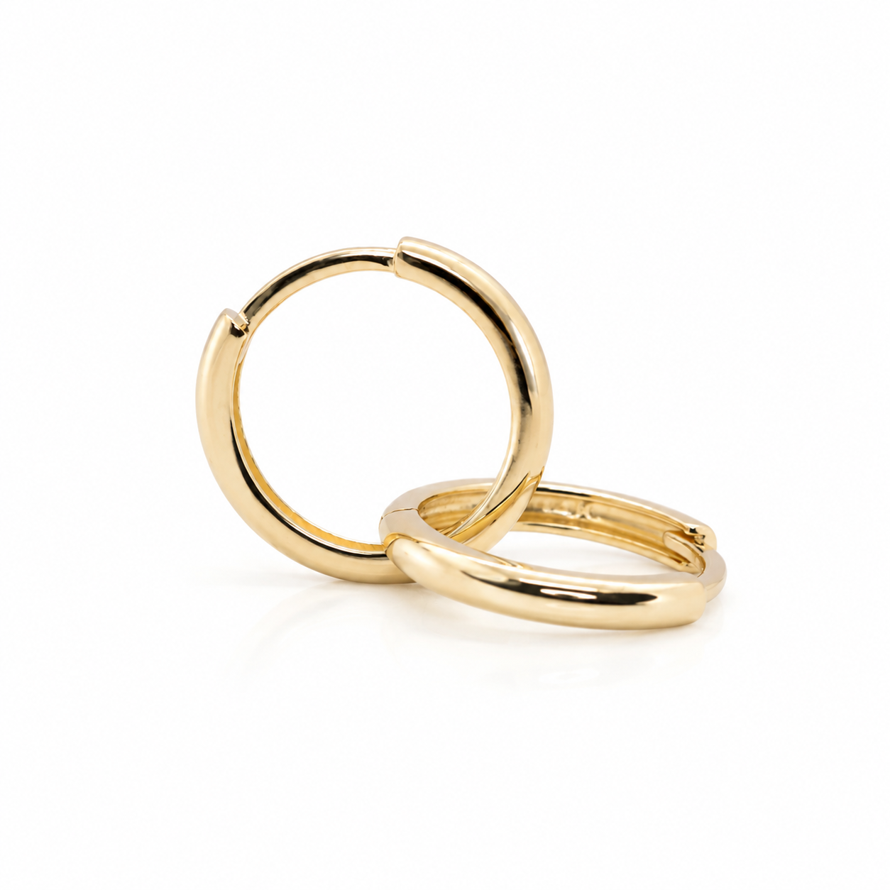 14K solid yellow gold huggie hoop earrings in two available sizes, featuring a smooth polished finish and classic everyday design.
