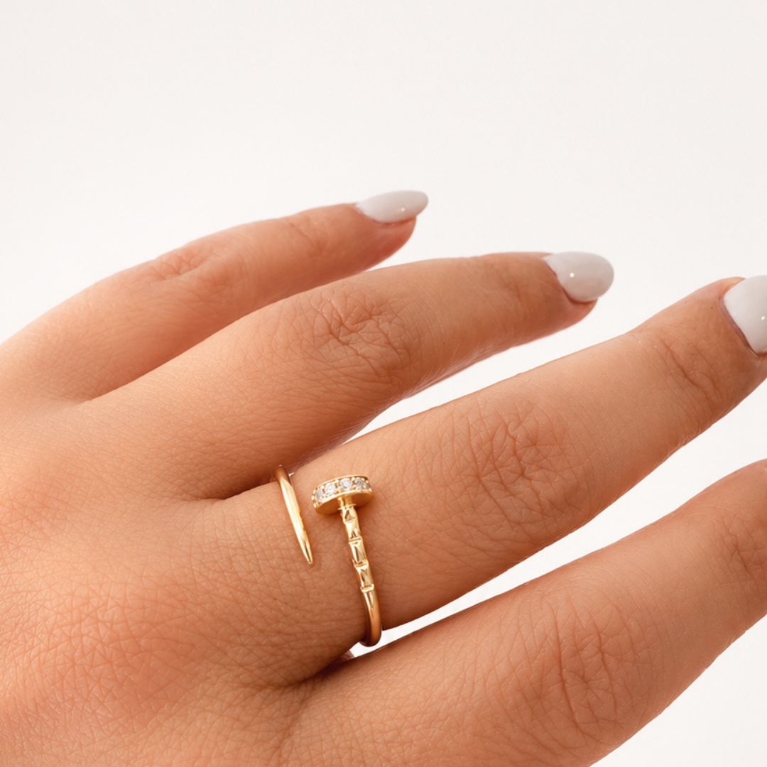 Model wearing a 14K solid yellow gold adjustable nail ring featuring clear CZ stones and a modern wrap-around design.