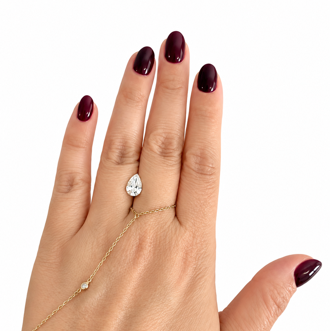 IGI certified 1.41 carat E VVS2 pear-shaped lab-grown diamond shown on hand for size reference.