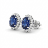 14K white gold sapphire and diamond halo stud earrings featuring oval lab-grown blue sapphires with secure screw backs.