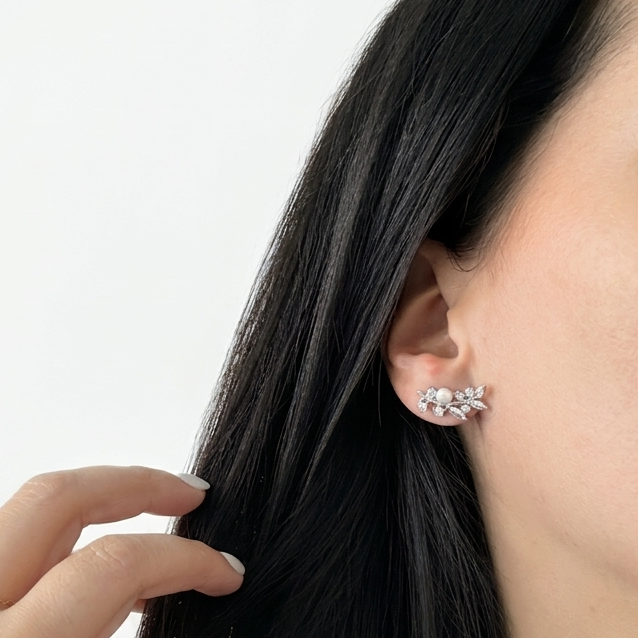Woman wearing silver-tone floral ear climber earrings featuring sparkling cubic zirconia stones arranged in a delicate leaf and flower design along the ear.