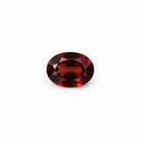 Oval 7 x 5mm garnet loose gemstone with deep red tones on white background