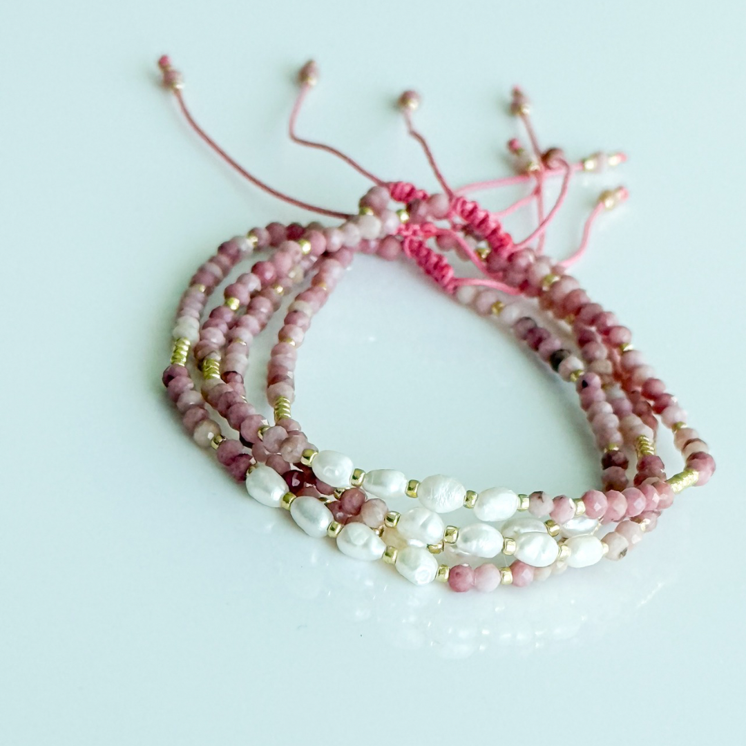 Beaded bracelet with pink and white beads on a light gray background